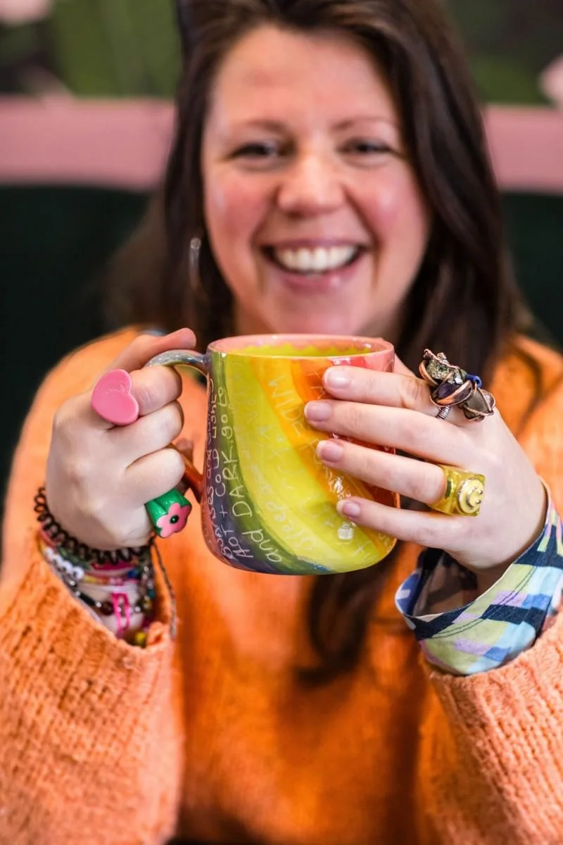 Sara Maxwell holding a hand painted colourful mug