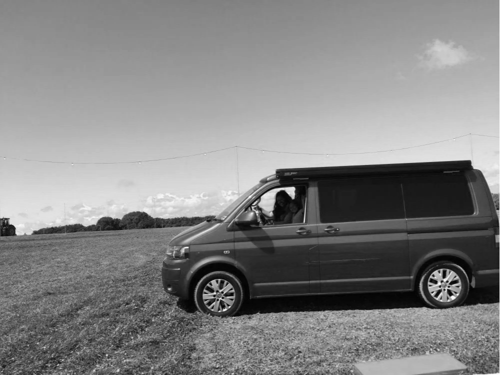 The Wealth Coach camper van in an open field