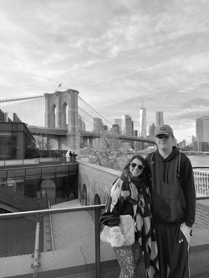 Sara in front of a bridge in the US with her son