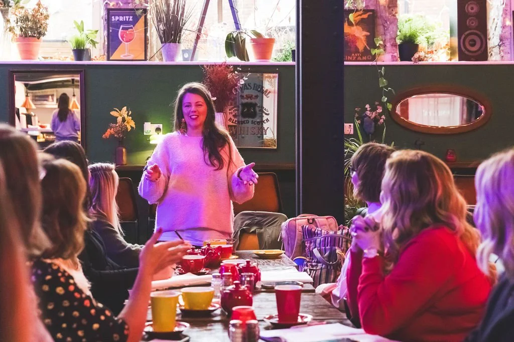 Sara Jane Maxwell at Wealth Coach leads an informal financial coaching workshop in a cafe for a table of participants