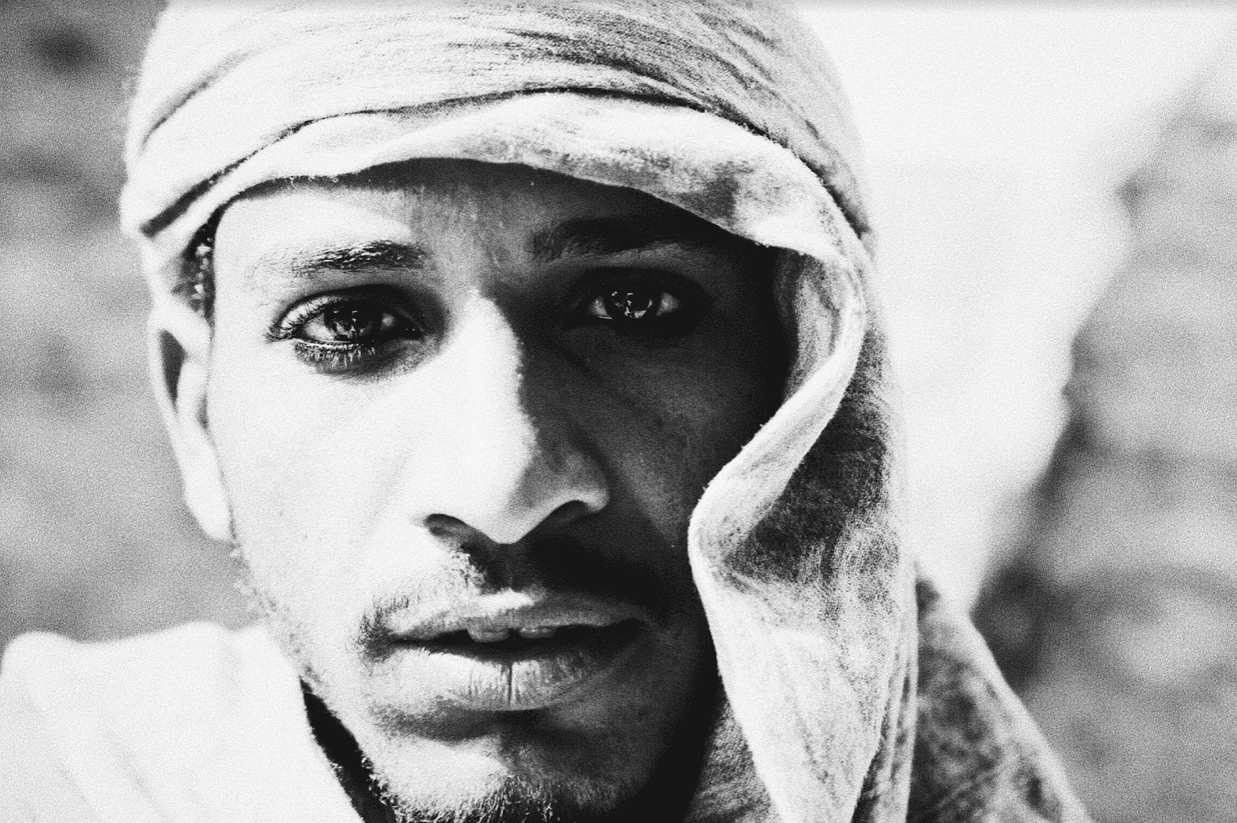 Black and white portrait of person wearing a headscarf.