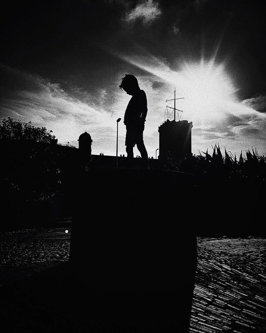 Silhouette of a child statue against the sun in a park