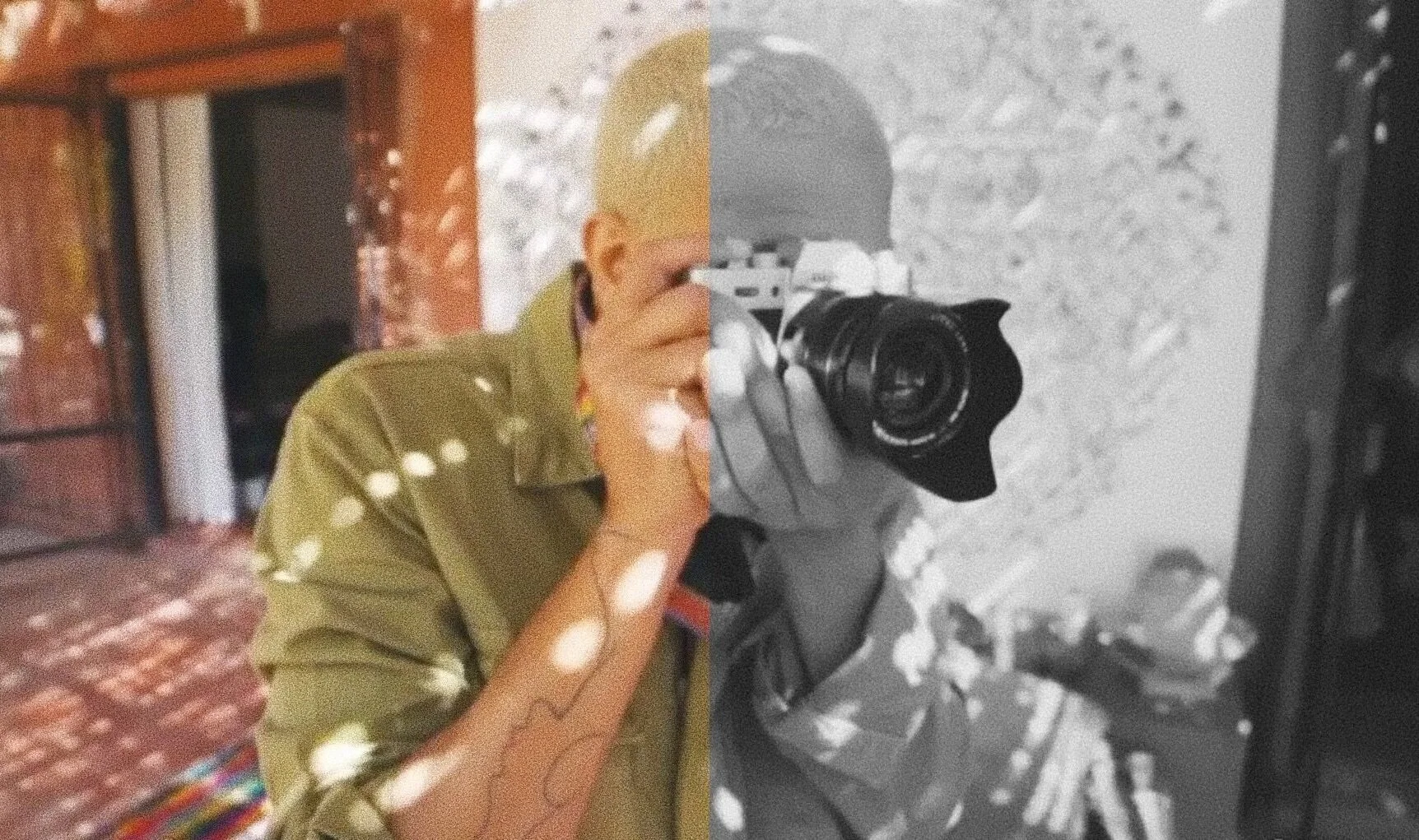 Person holding a camera, half-color, half-black-and-white effect, indoors with a patterned shadow on the wall.