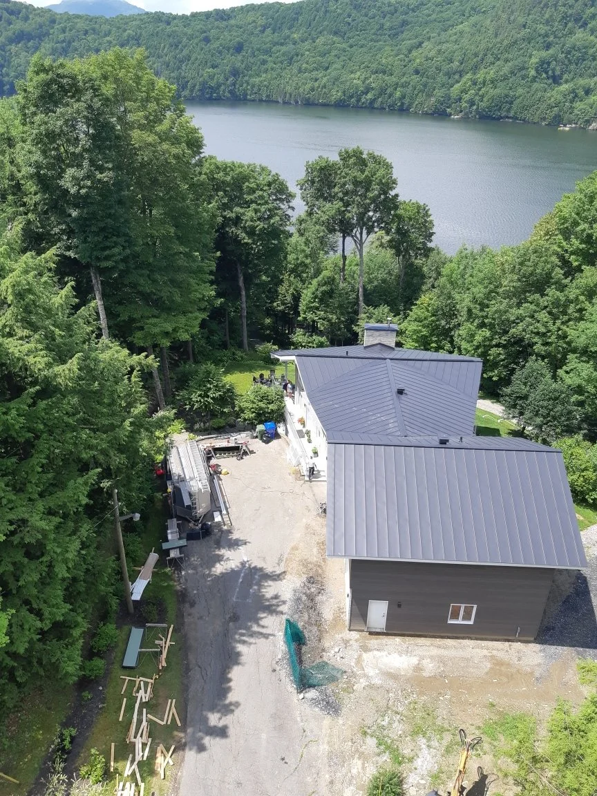 Vue aérienne d’un chantier résidentiel, installation de toiture métallique, réalisé avec des matériaux durables et un souci du détail.