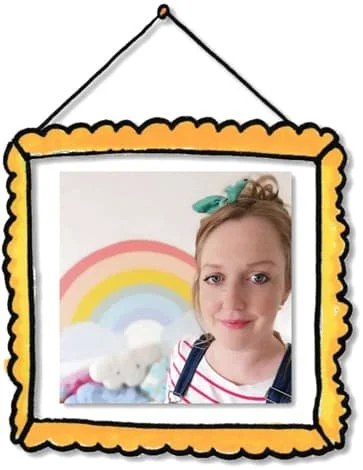 Illustrated portrait of Laura with blonde hair, wearing denim dungarees and a striped top, shown inside a hand-drawn yellow picture frame. A pastel rainbow and soft toys appear in the background.