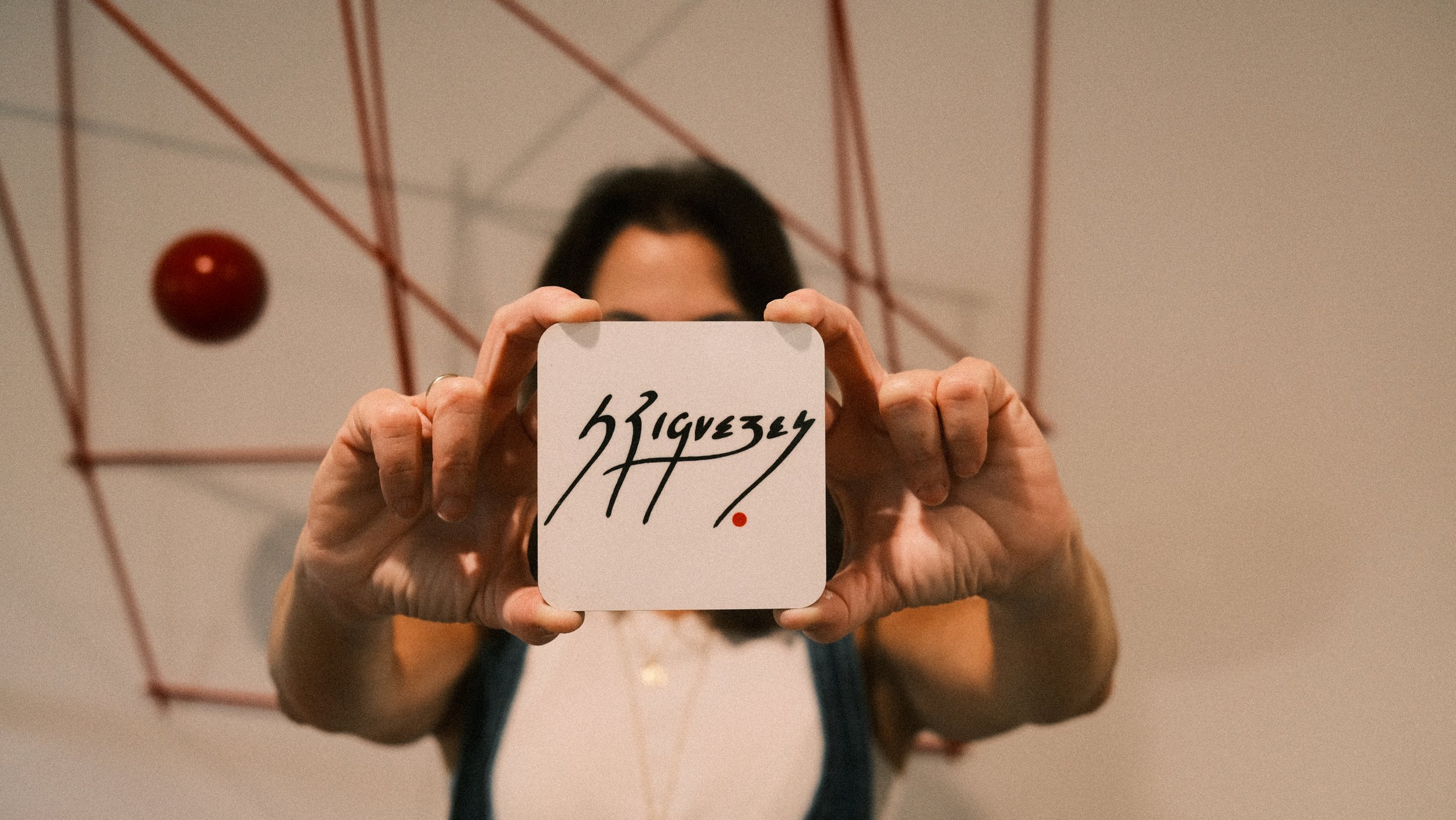 Sylvia Riquezes showing off her signature in front of her kinetic sculpture.