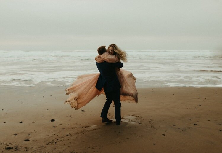 bride and groom spinning on beach after vow ceremony.jpg