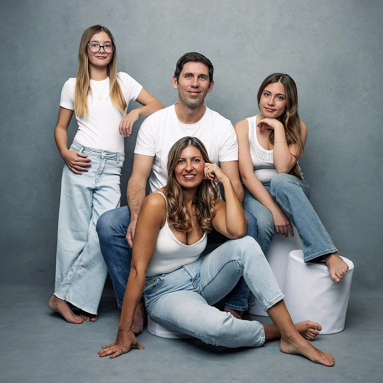 Vierköpfige Familie lächelt gemeinsam beim professionellen Portraitshooting im Fotostudio Innsbruck, Österreich