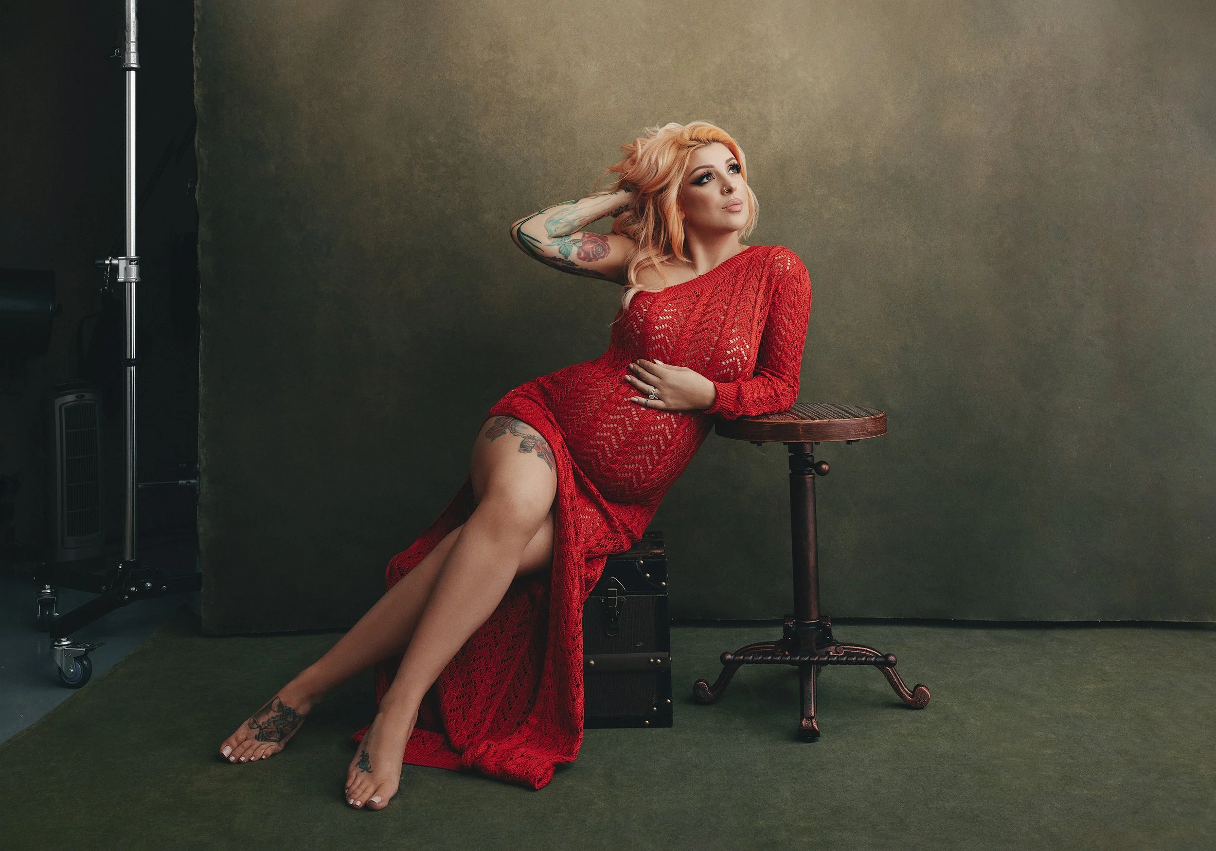 Editorial maternity portrait of a pregnant woman in red dress by portrait photographer Mayumi Acosta Innsbruck Austria