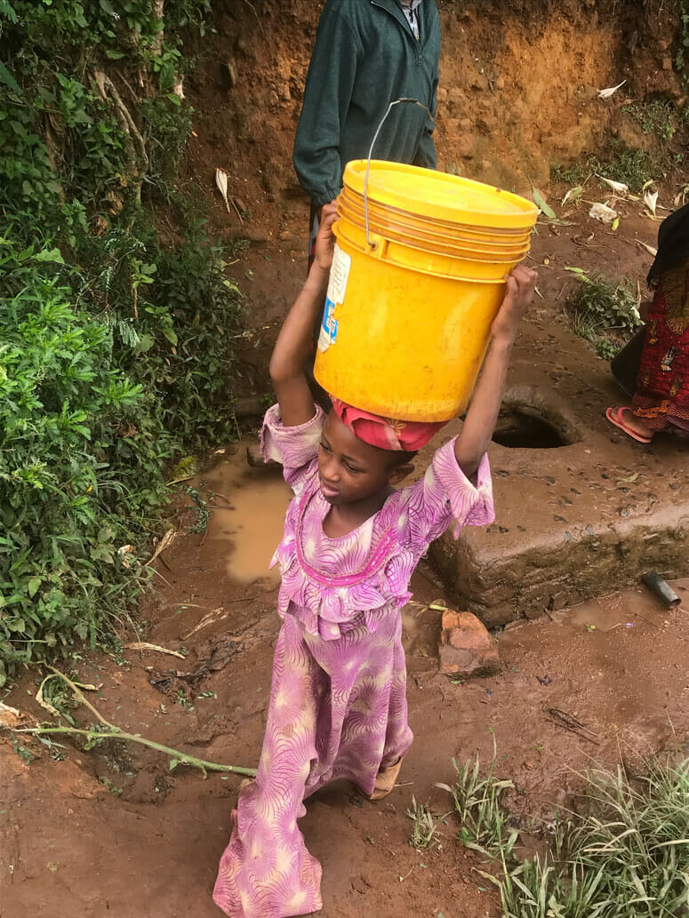 A child carrying water from the well in Mambo.