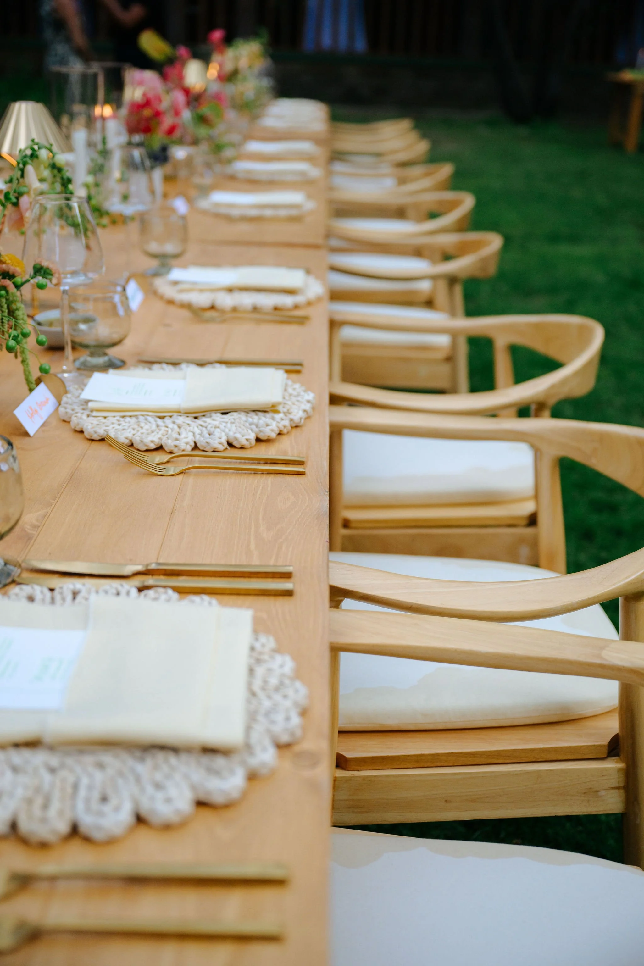 Wedding reception arched back barrel chairs, rattan chargers, gold lamps and modern tabletop