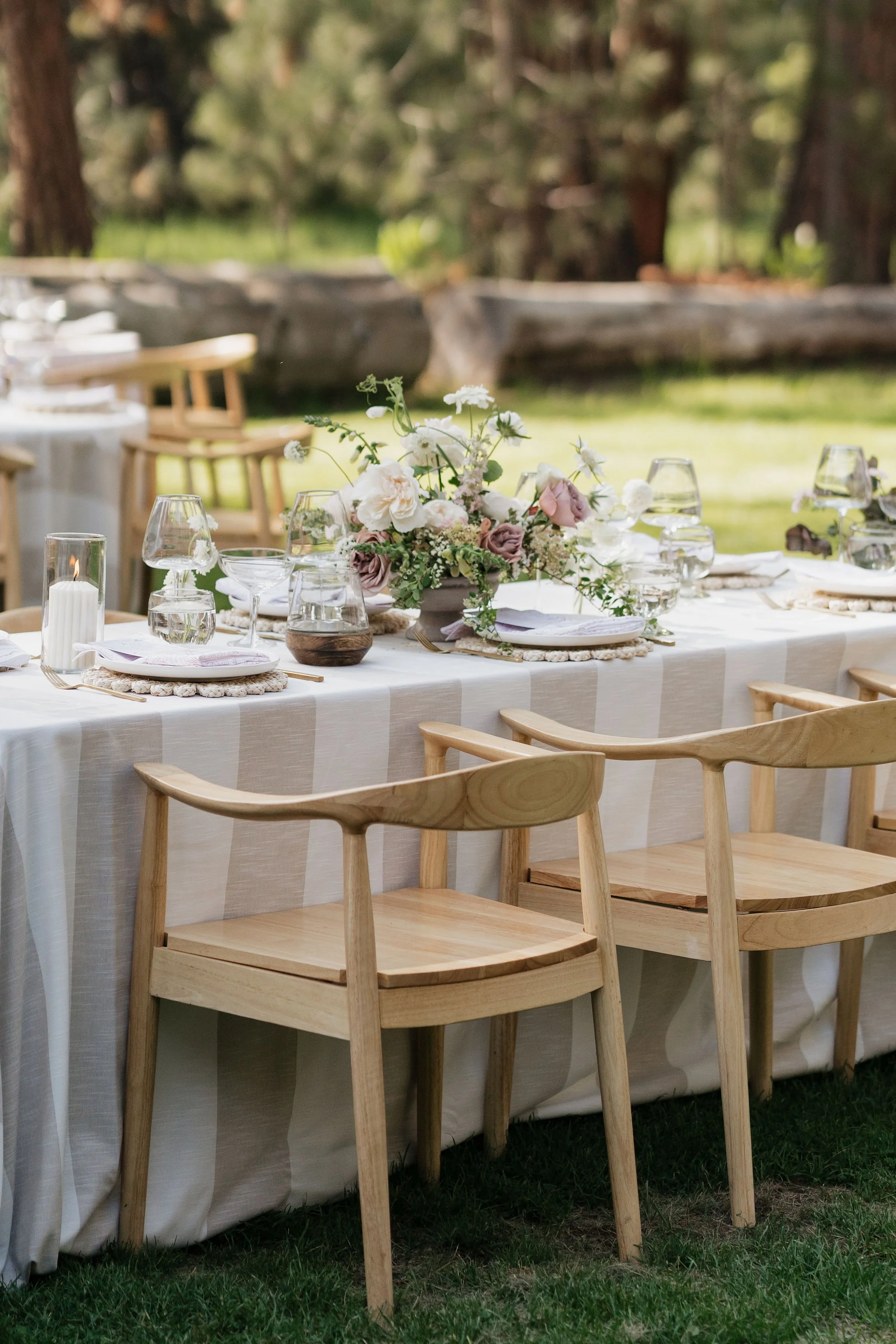 Strip linens with light wood chairs for an outdoor wedding