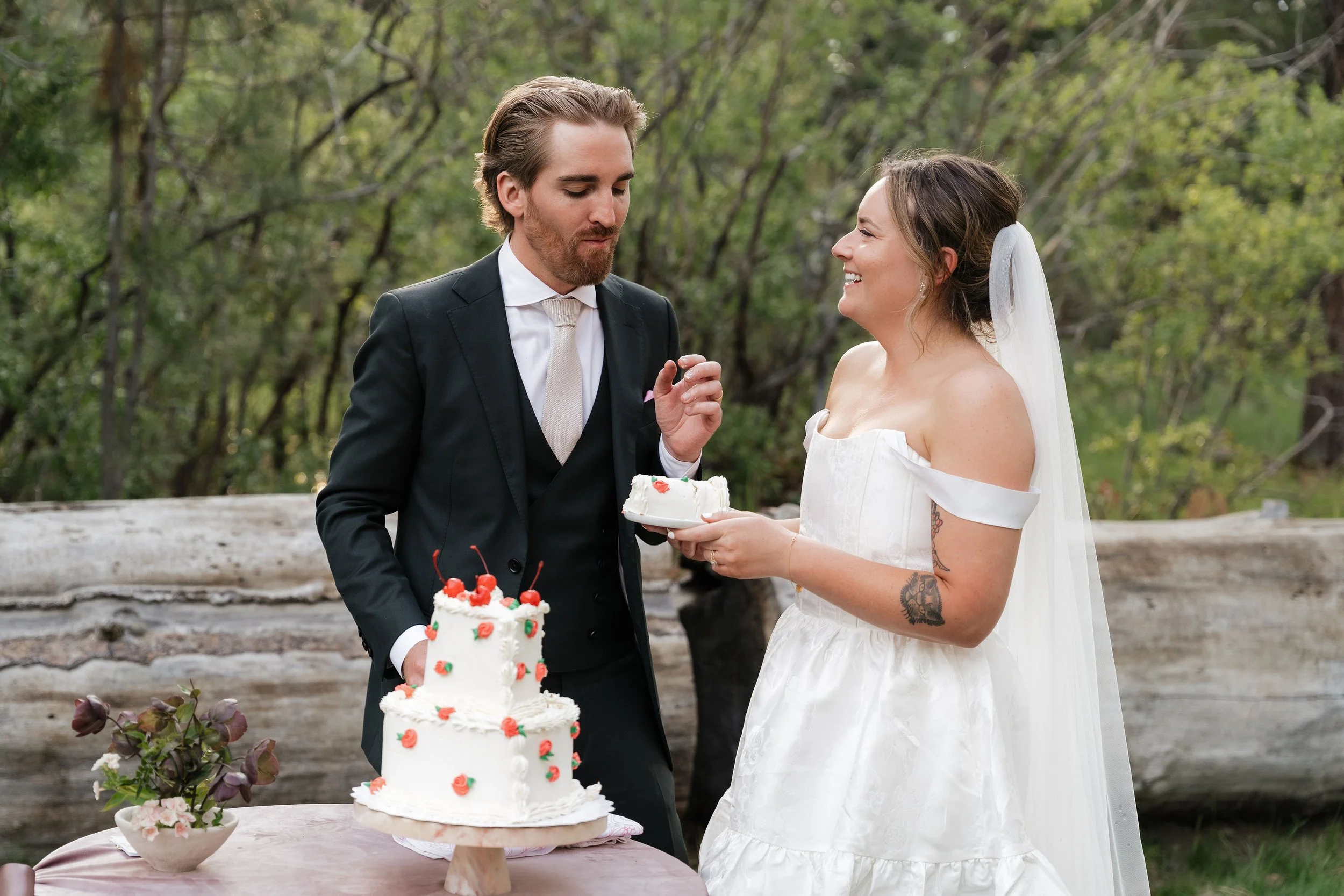 Heart shaped two tier wedding cake with red flower detail & cherries on top