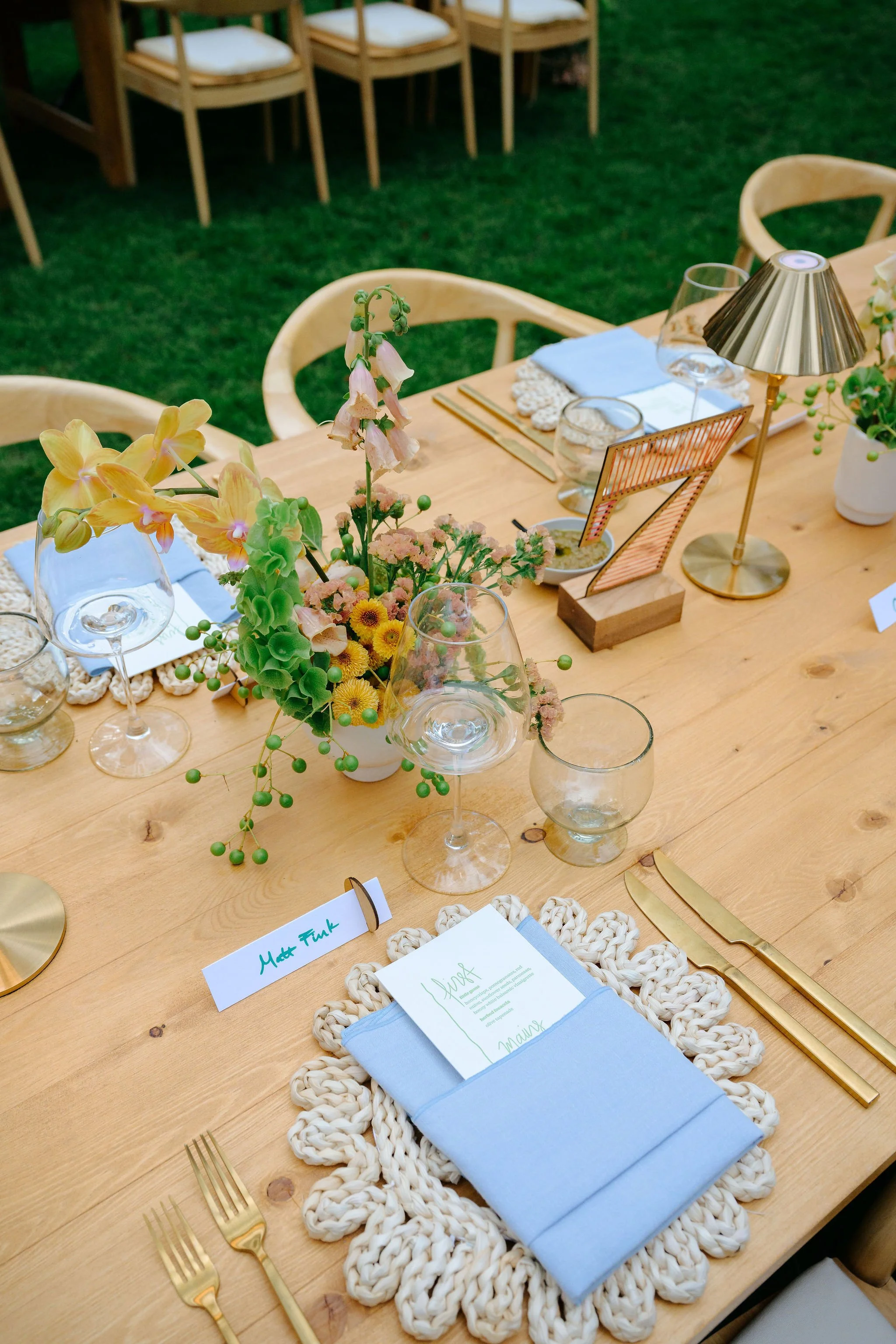 Wedding reception with a mix matched cohesive design. Blue accents with butter yellow and pops of orange