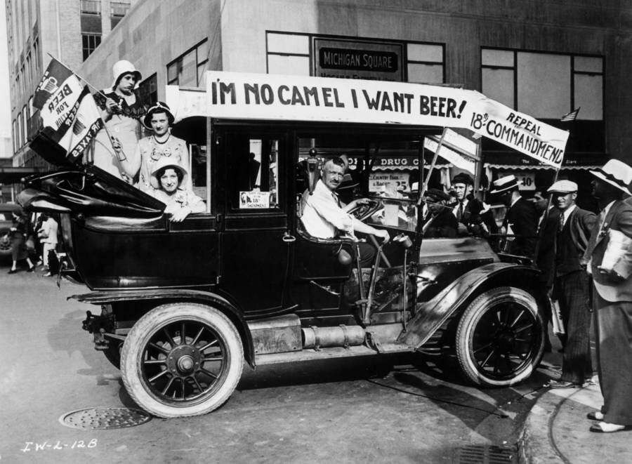 Prohibition protesters parade in a car emblazoned with signs and flags calling for the repeal of the 18th Amendment, 1923.