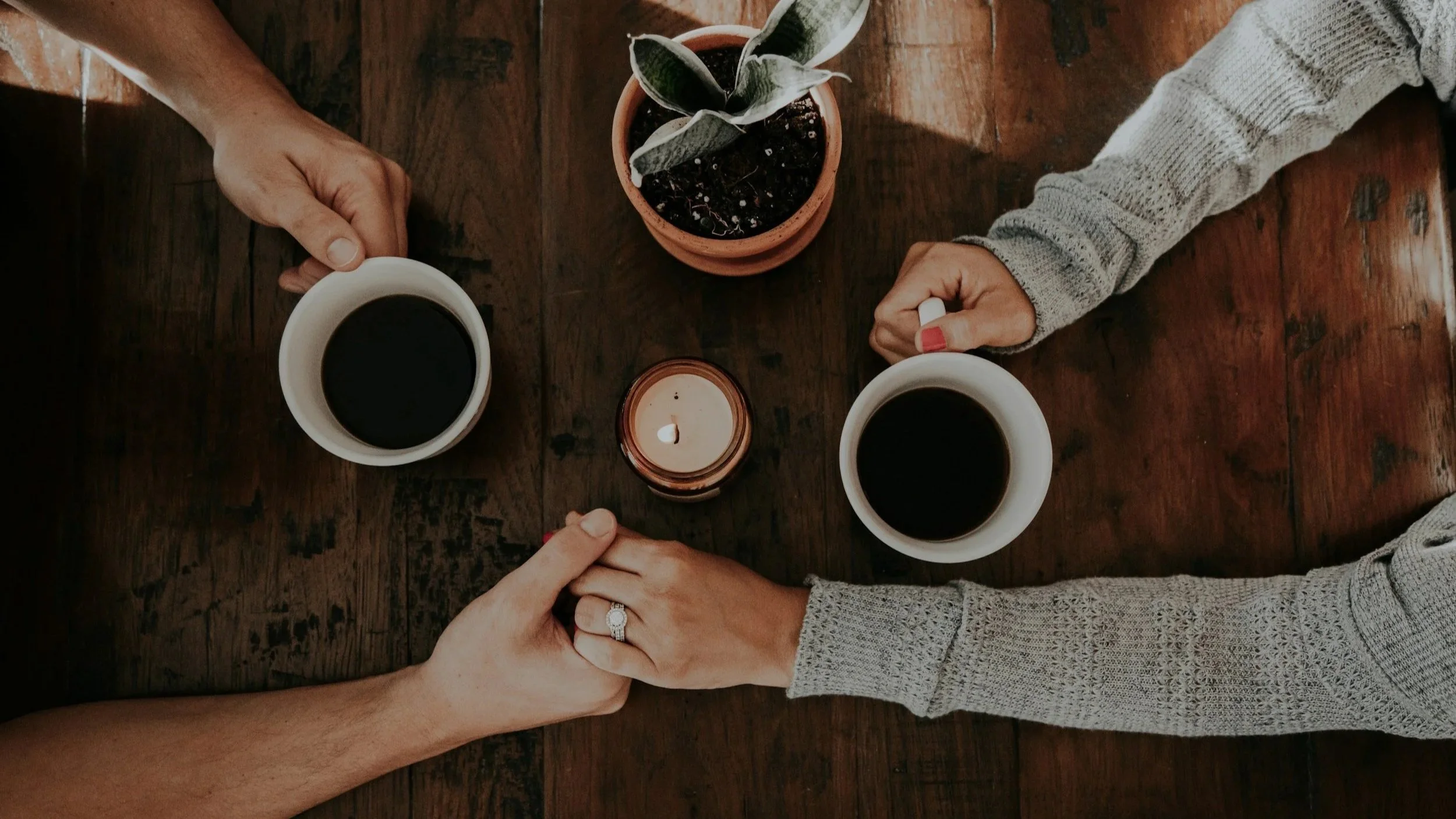 Couple holding hands and coffee