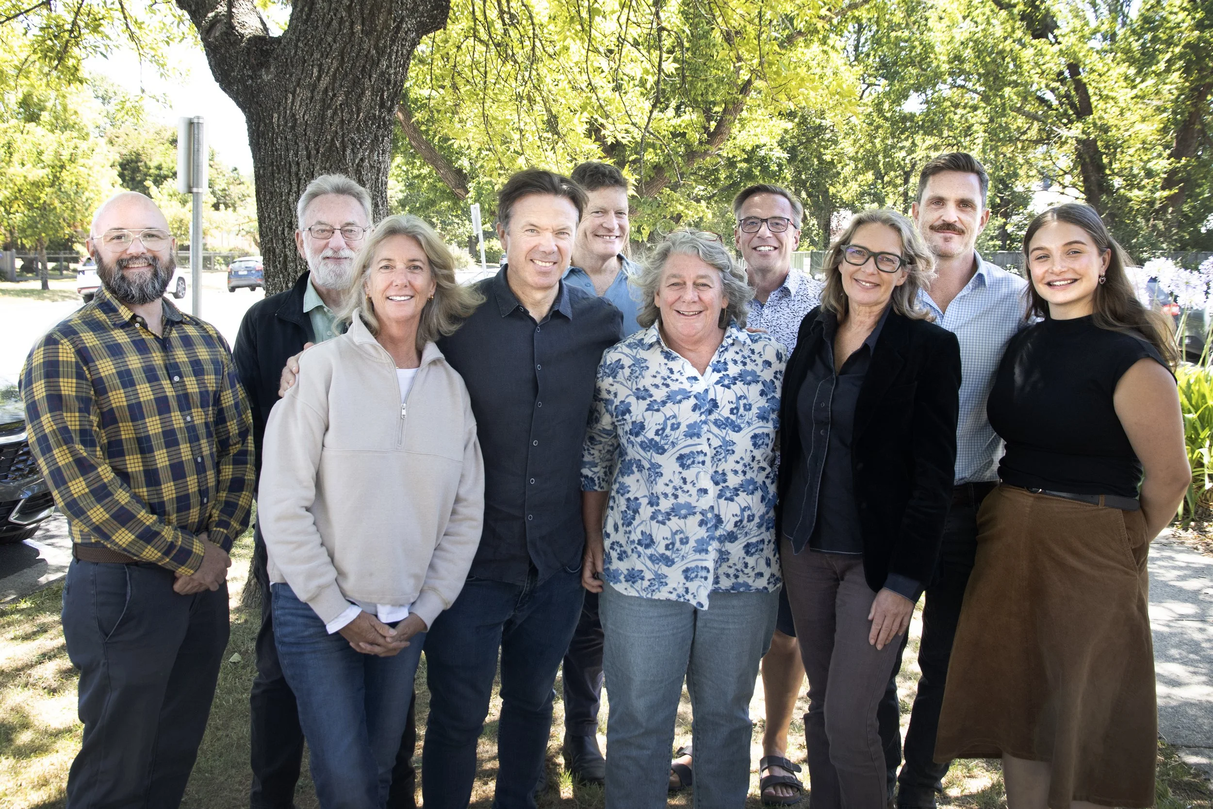 Ten members of the Live4Life Board standing on a leafy street
