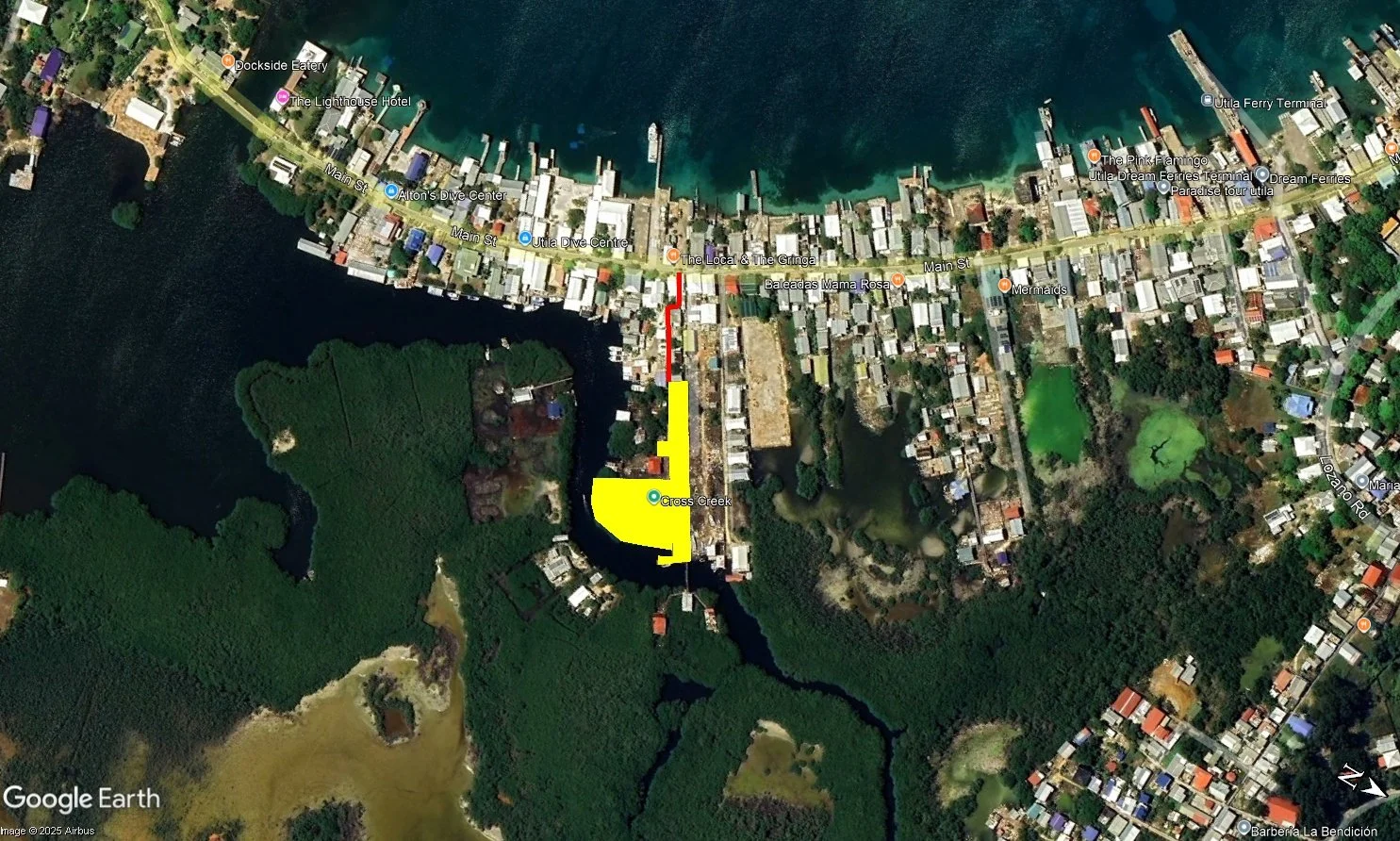 Satellite map of a coastal town with a waterway running through the center. There are numerous small buildings along the streets and water, with a marked route in yellow and red. The area includes docks, a ferry terminal, and various labeled points of interest.