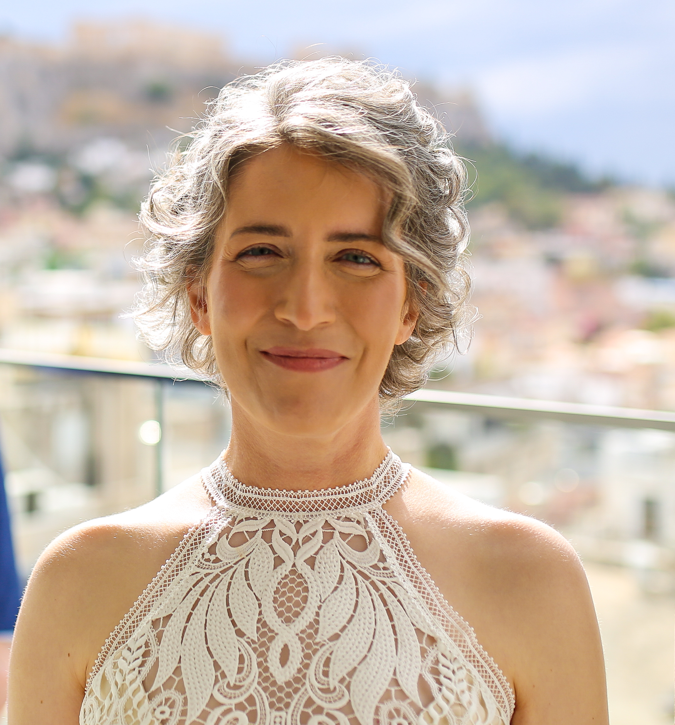 Woman smiling wearing a lace shirt