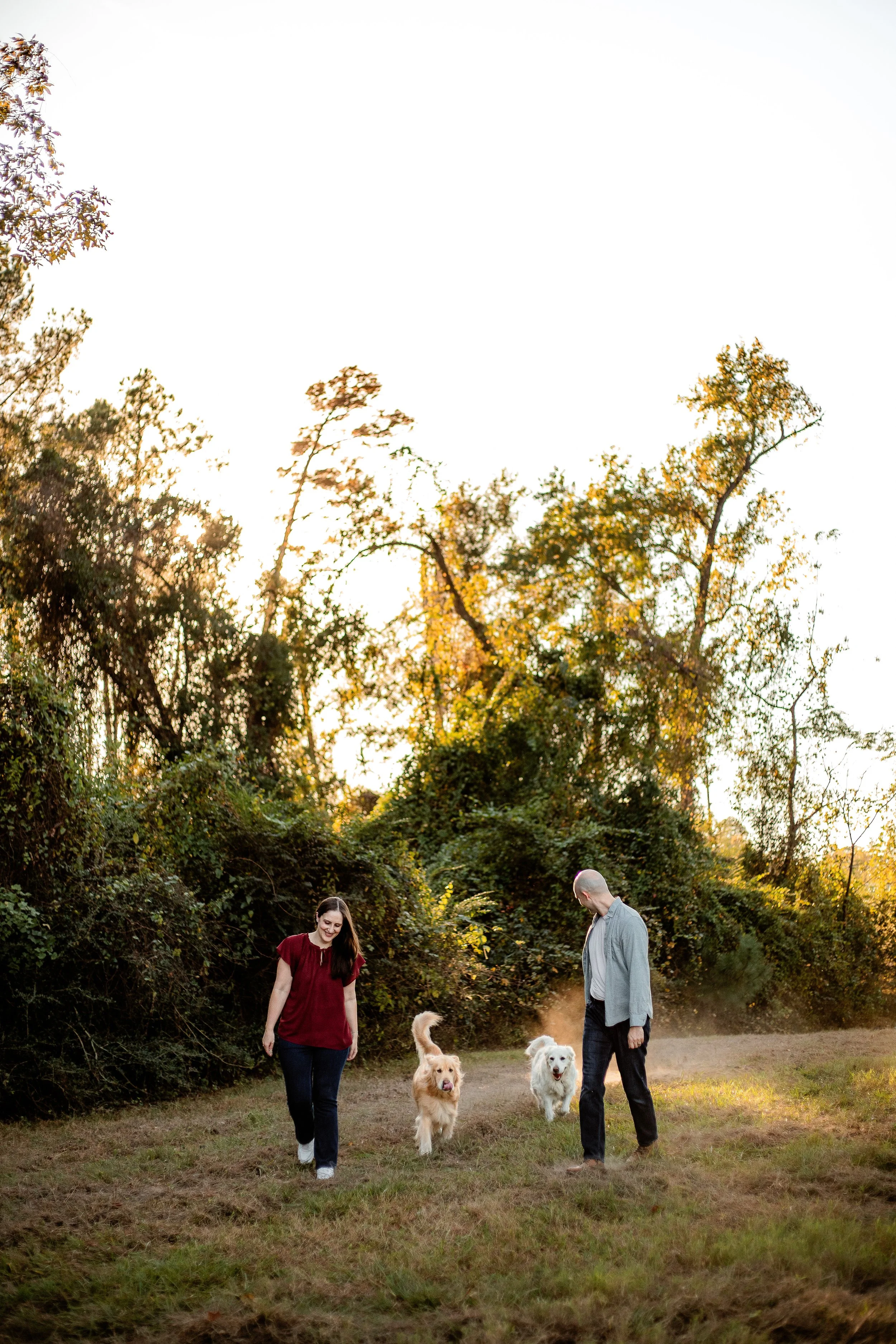 Dog parents running together during an outdoor photography session in Spring, Texas