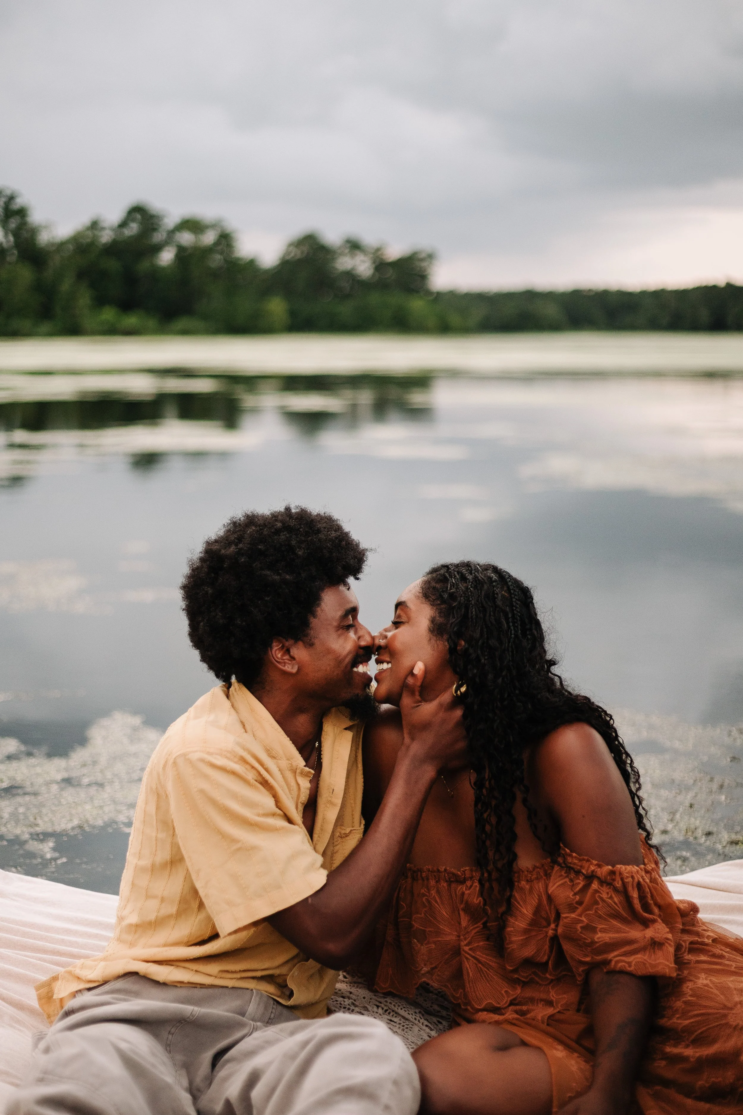 A happy couple embracing each other while smiling into a kiss for a couples photoshoot in The Woodlands, Texas