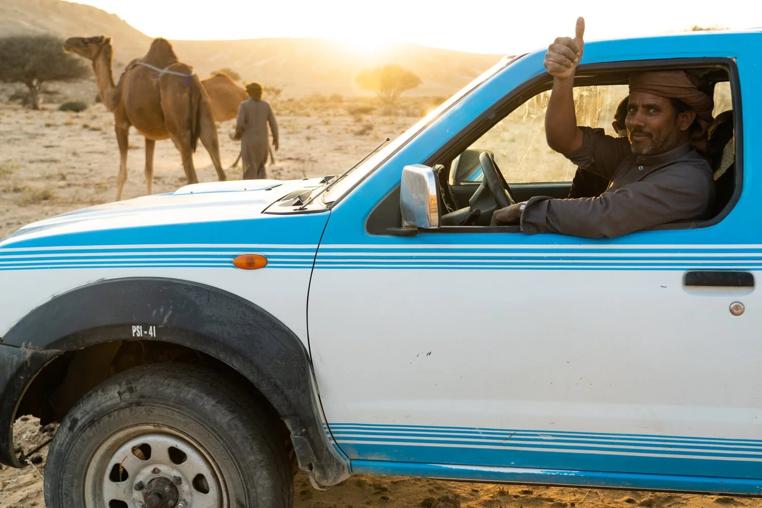Thumbs up from the driver after finishing milking the camels in Yemen’s Empty Quarter Desert.