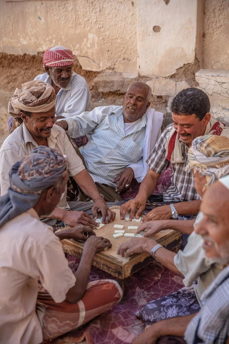 Hadhrami men play a game of dominos inside the walled city of Shibam. Hadramaut, Yemen.