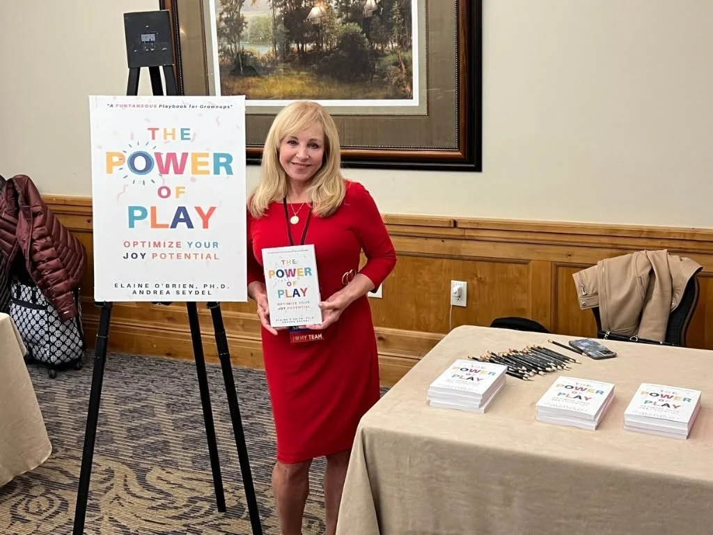 Elaine O'Brien holding a book titled "The Power of Play"