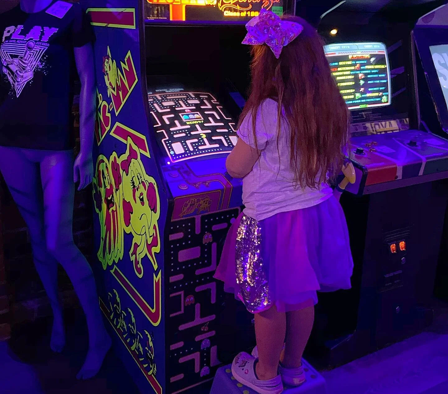 little girl playing ms pac man.jpeg