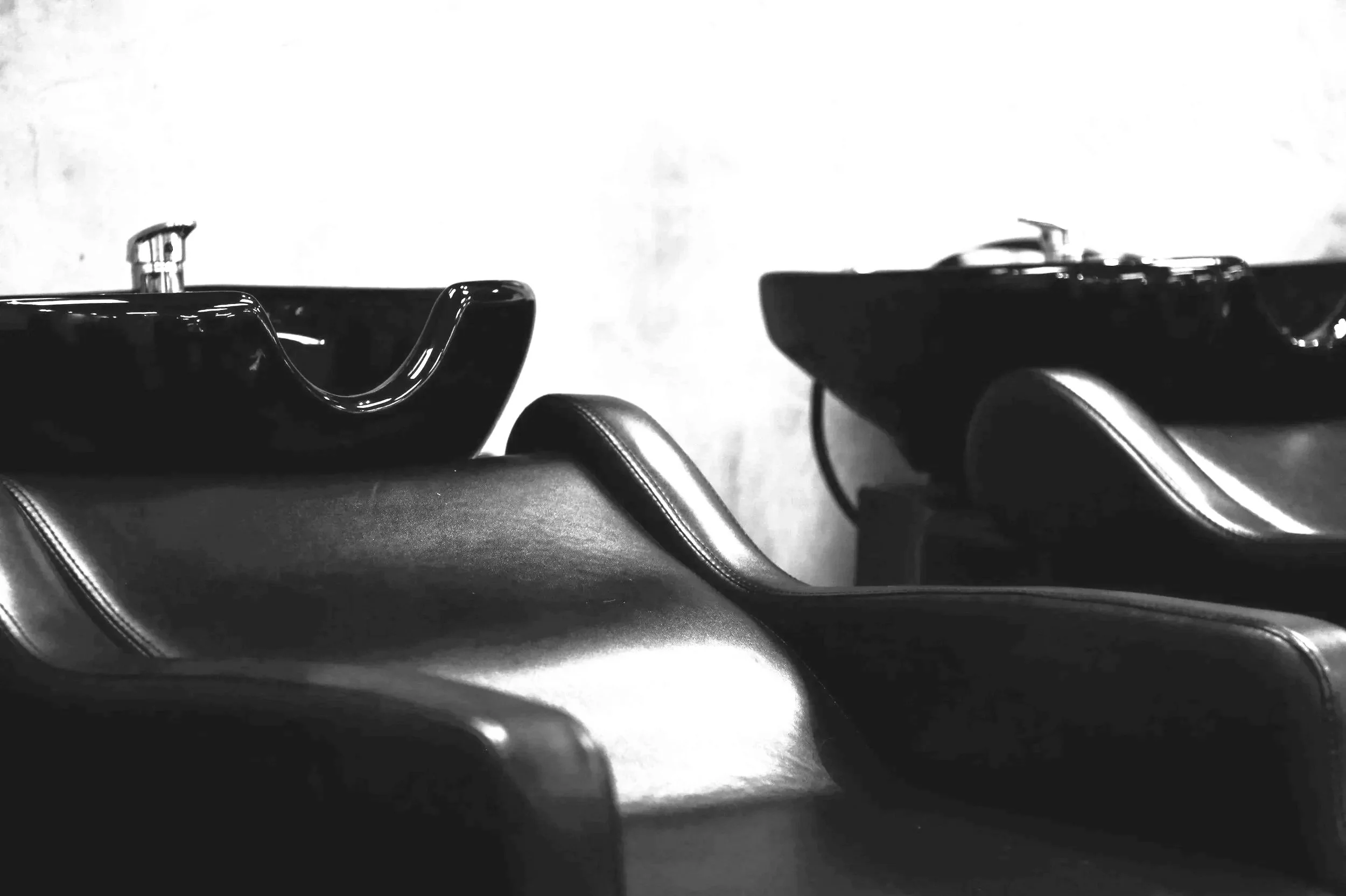 Black salon shampoo bowls and chairs in a salon setting in black and white