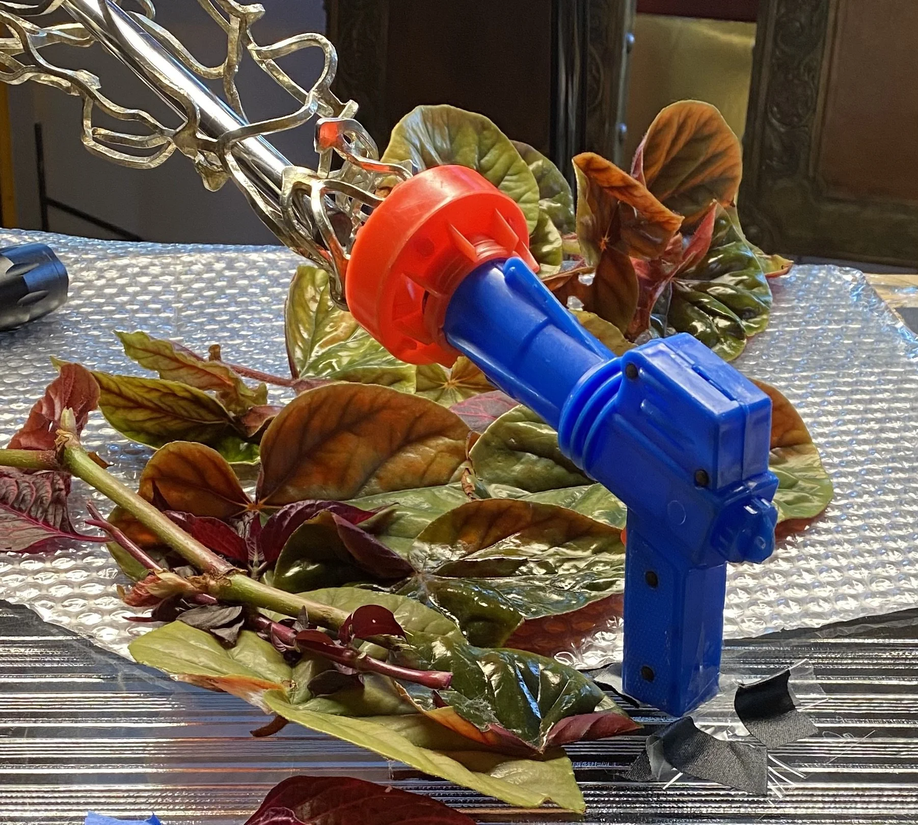 The toy ray gun with leaves arranged around it while Mark Robert Halper creates the photograph.