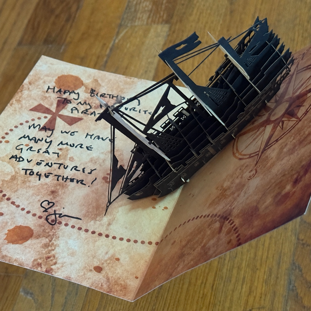 The paper pop-up pirate-ship card from Jen, with her handwritten message about adventures together.