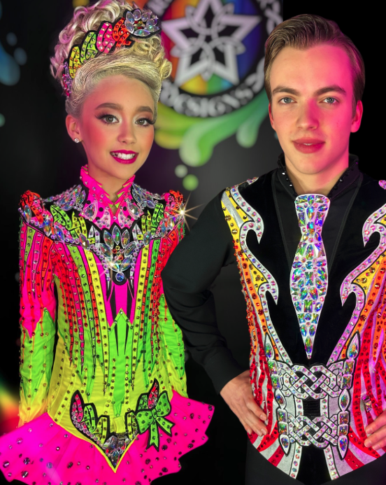 Girl and boy dressed in colorful, sparkly clown costumes with bright makeup, posing against a black background.