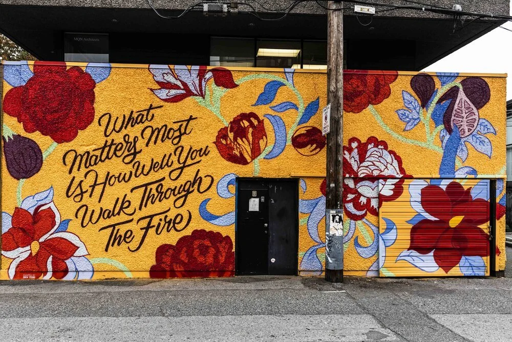 Orange textured wall with spray painted flowers and text that reads 