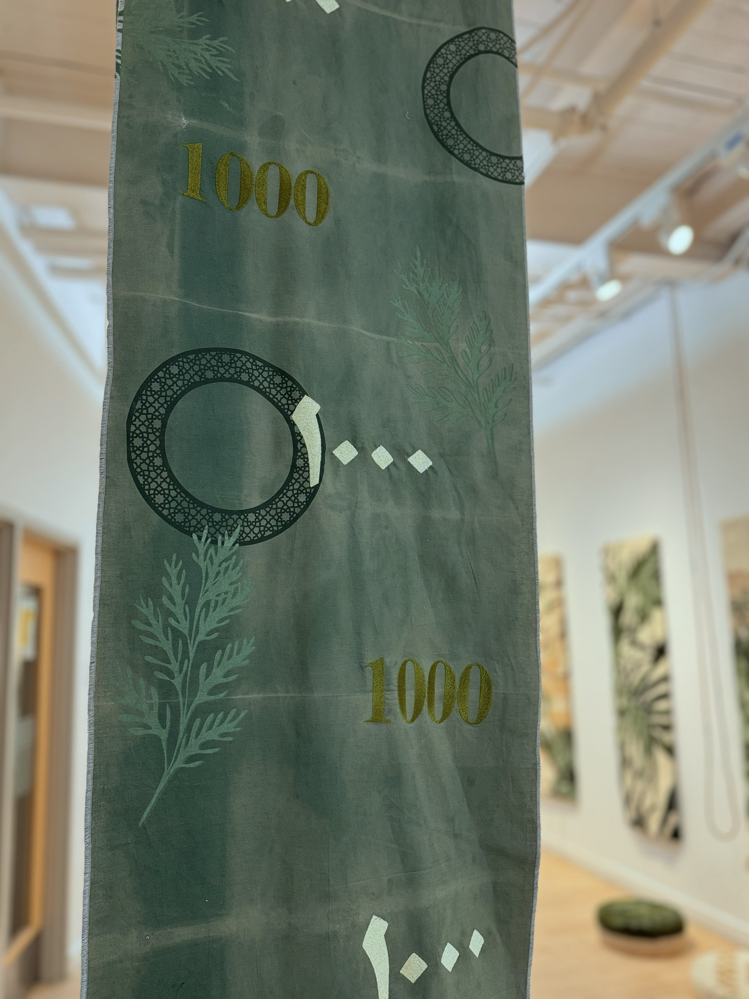 Building Steam with a Grain of Wheat (1000 Sudan) 96 × 18 in 

Bleach, embroidery floss, fabric paint, woven synthetic fibers, bank notes

2025