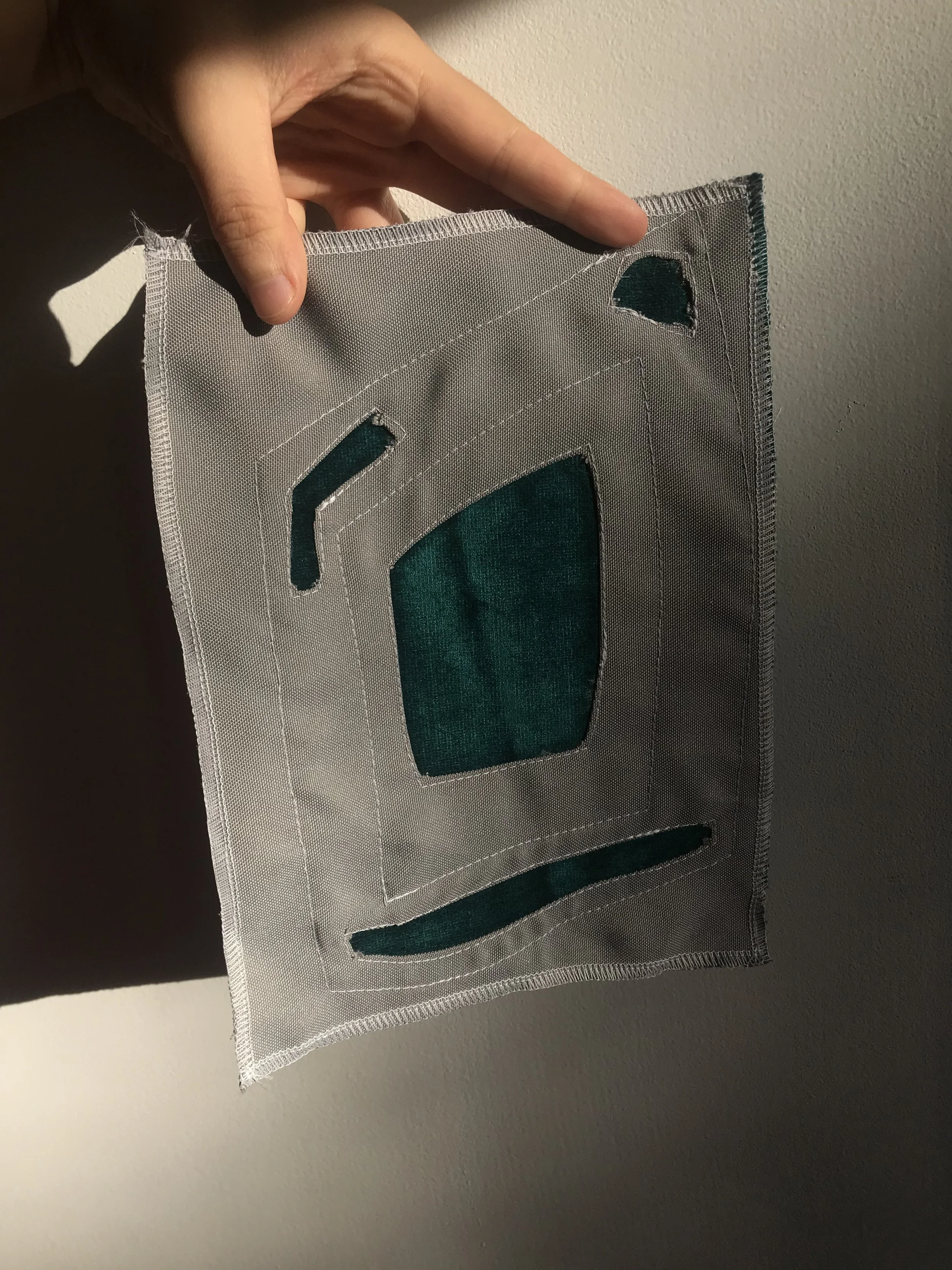 Mola sample: Grey Nylon top layer and Velveteen bottom layer, machine sewn with polyester thread. Outcome is perfect for upholstery/ decorative furnishings as both materials are hydrophobic, perfect for high traffic spaces and use. Material handle is