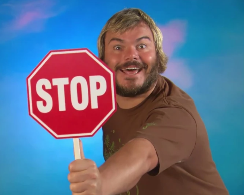 Actor Jack Black holds up a STOP sign.