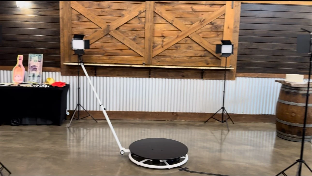 An empty dance or exercise studio with wooden walls, lighting equipment, and a round vibrating platform in the center.