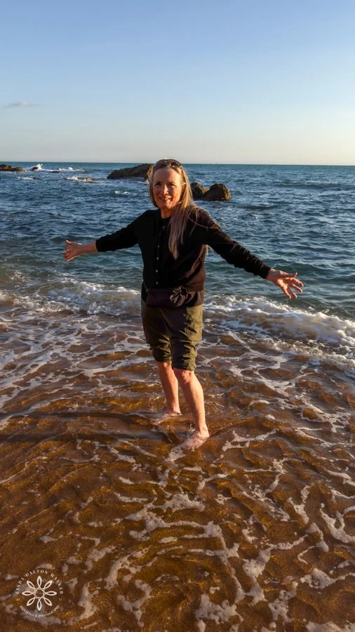 woman standing in sea getting feet wet