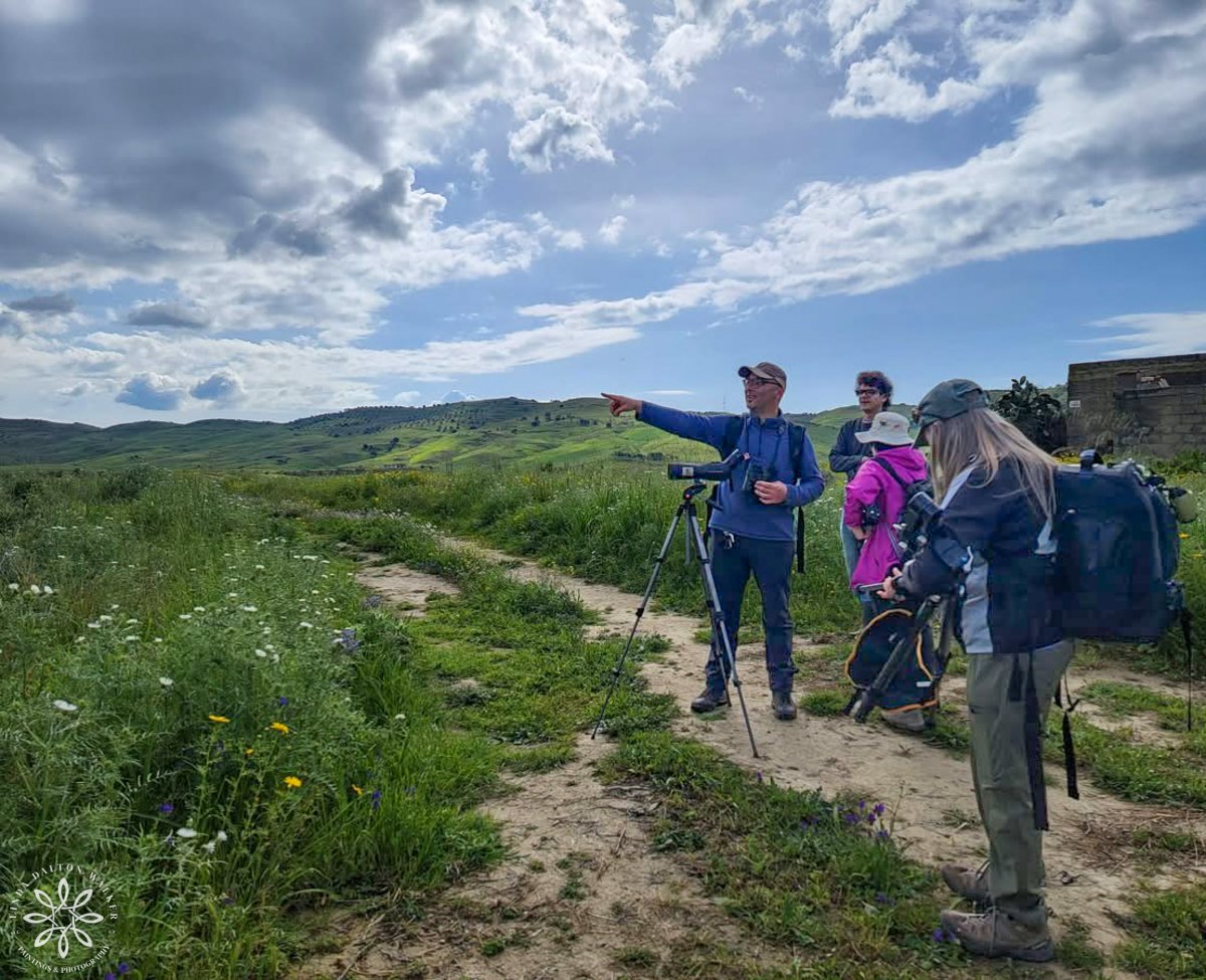 Four people, two women photographers and a male with a birding scope in a wetland, Sicily, italy