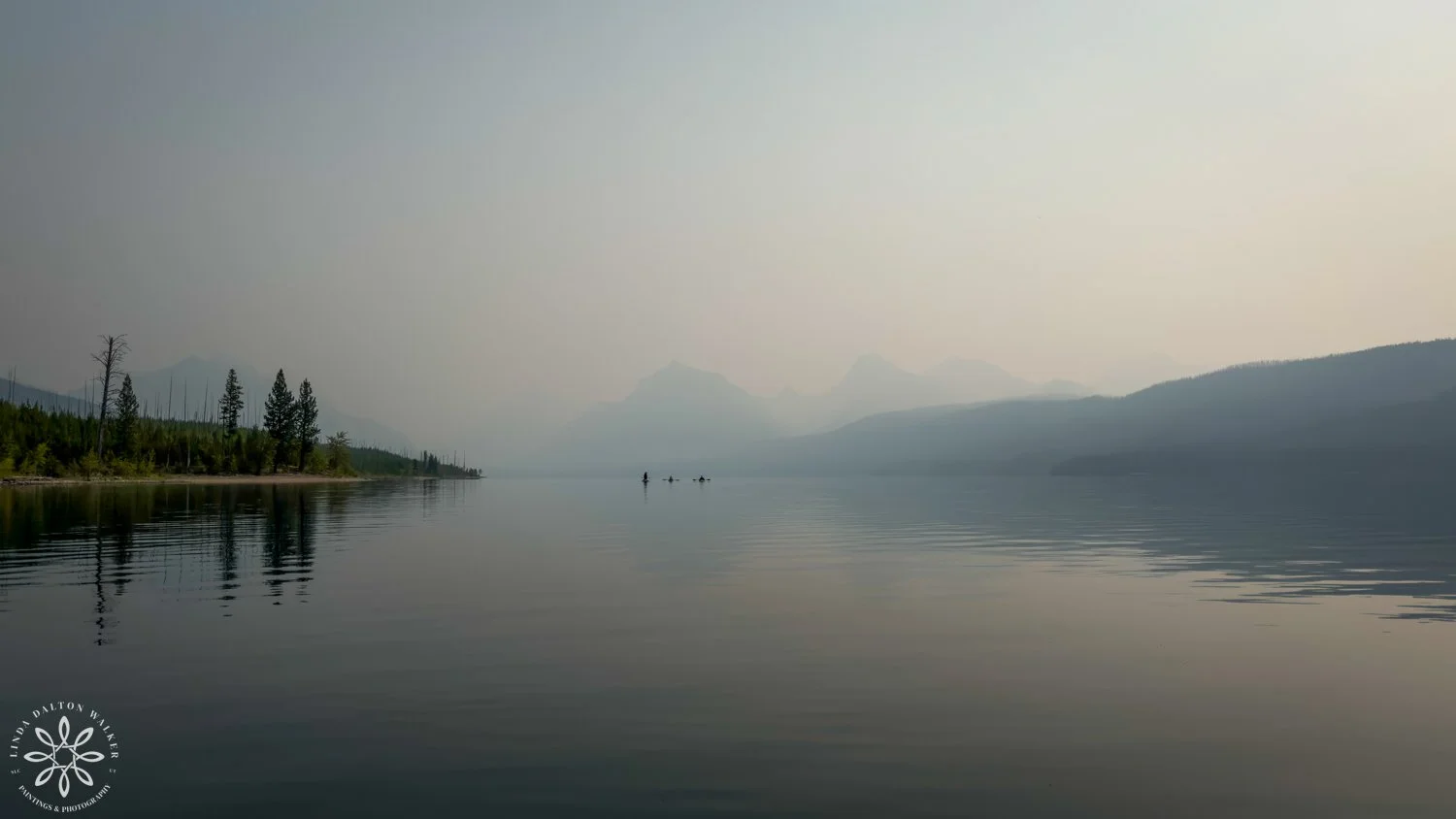 Three kayakers on Lake McDonald, early morning Glacier National Park