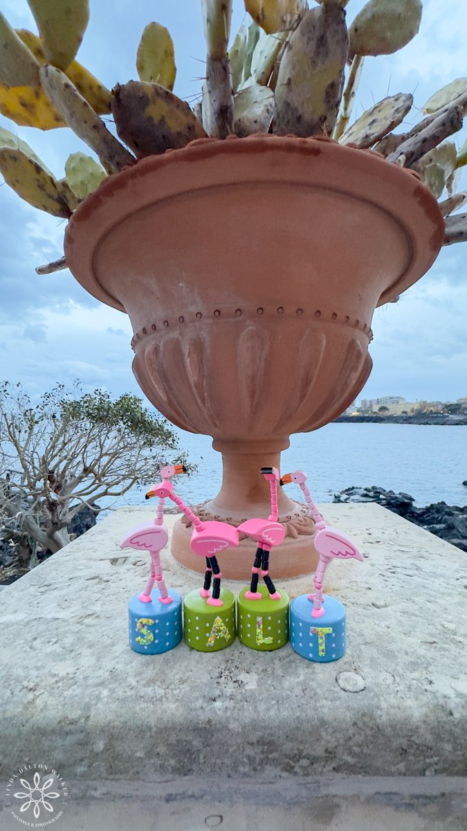Small Flamingo toys in front of vase, Sicily, Italy, fine art wildlife photography print by Linda Dalton Walker