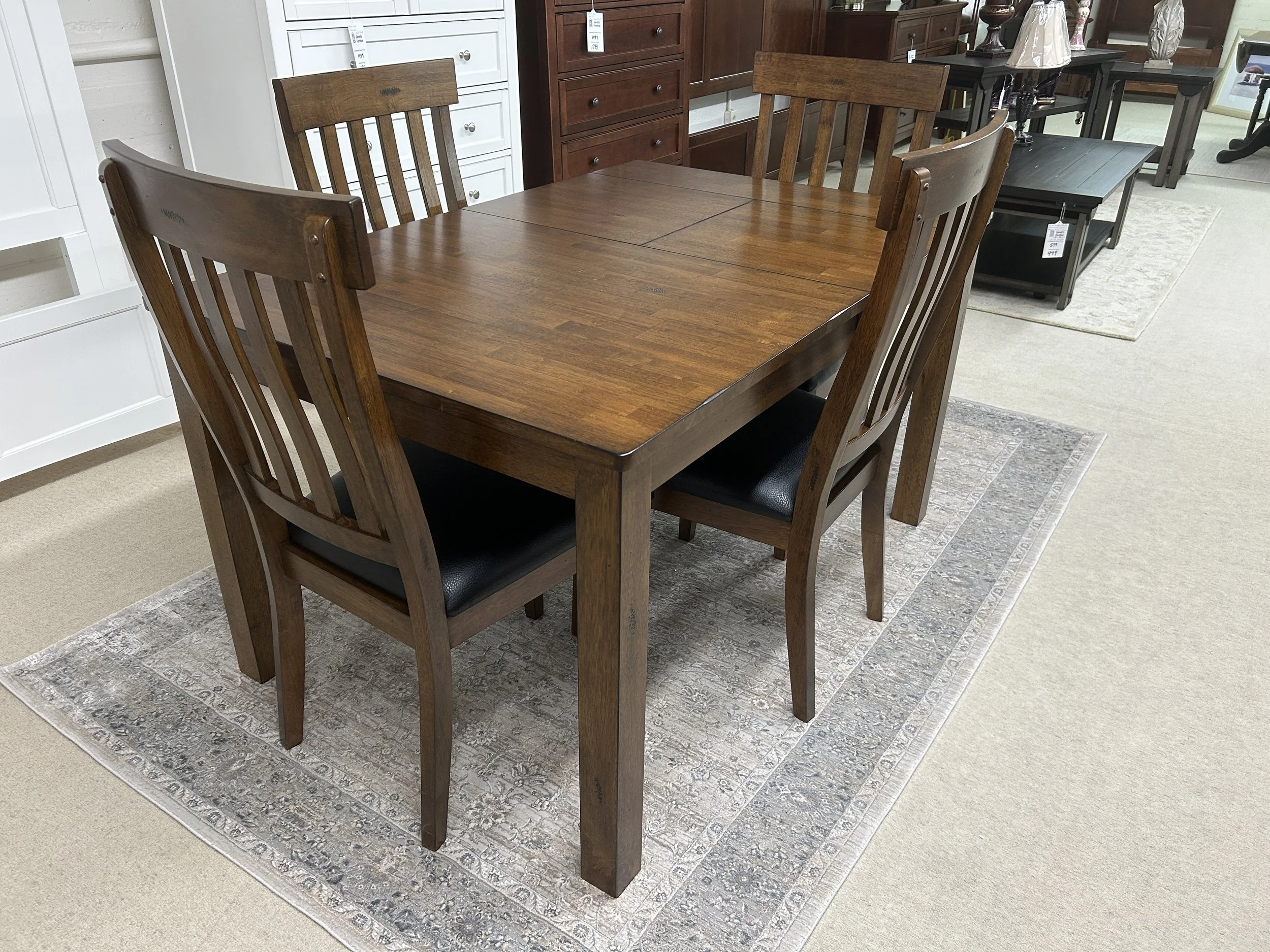 A-America: Mariposa solid hardwood dinette table with self-storing leaf (36"x36" expands to 36" x 54") in rustic whiskey finish.  Comes with four slat-back side chairs with upholstered seats.