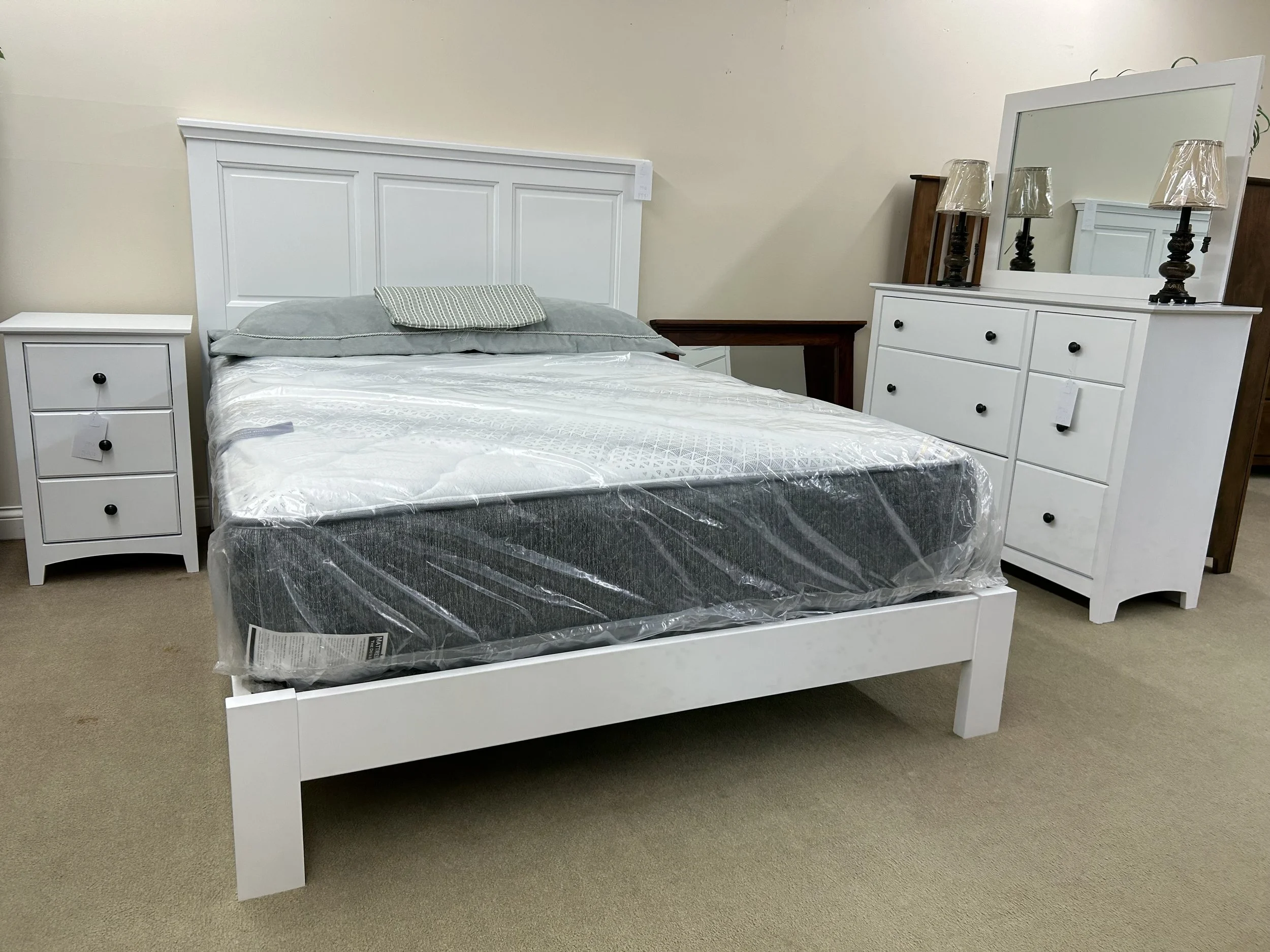 Archbold solid hardwood bedroom set in Snow White finish: Queen raised panel bed with low footboard, six drawer dresser with mirror, and three drawer nightstand