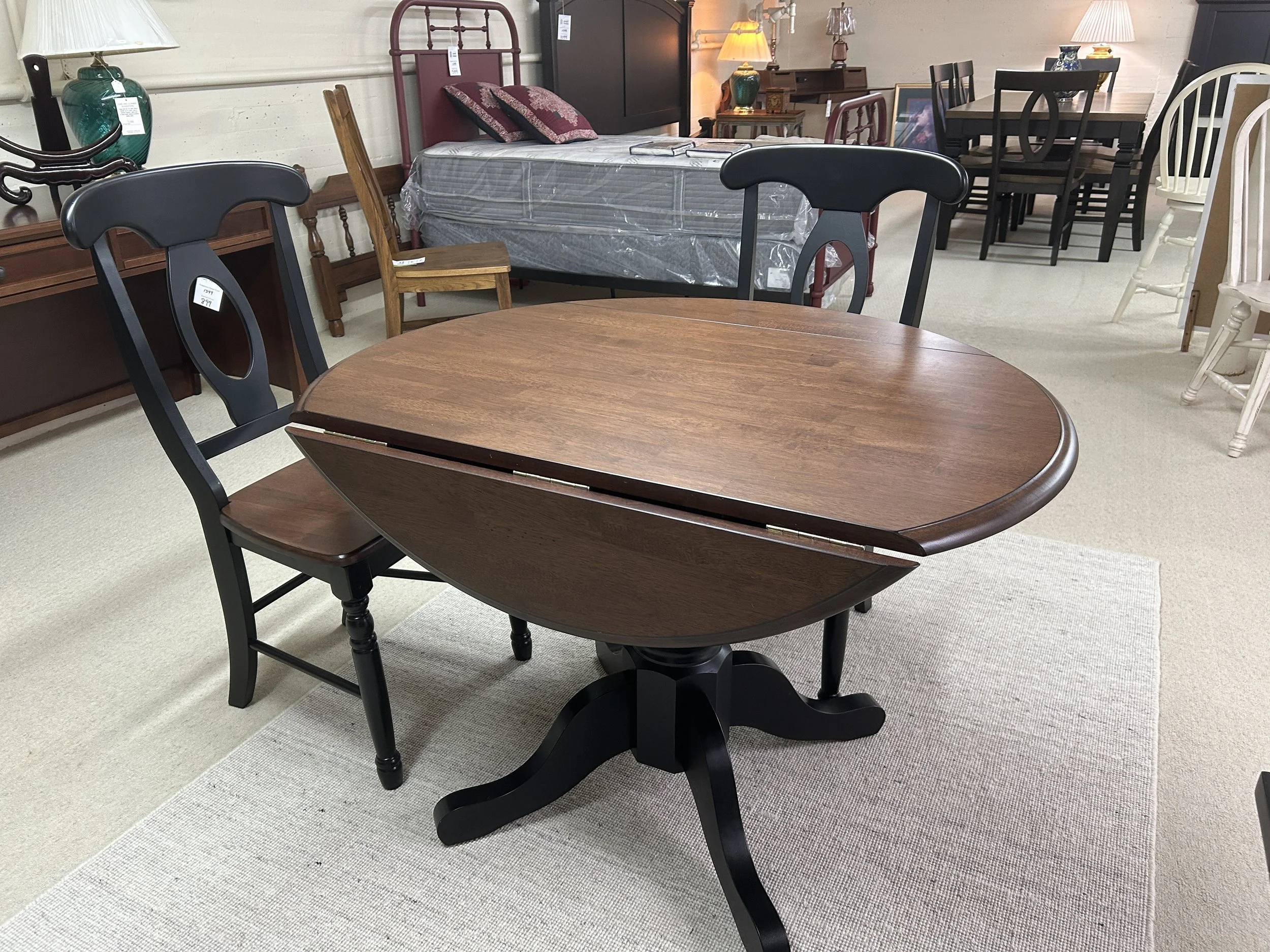 A-America: British Isles collection 42" round drop-leaf table with pedestal base in two-tone finish: oak and black on solid hardwood.  Comes with 2 two-tone Napoleon style side chairs.