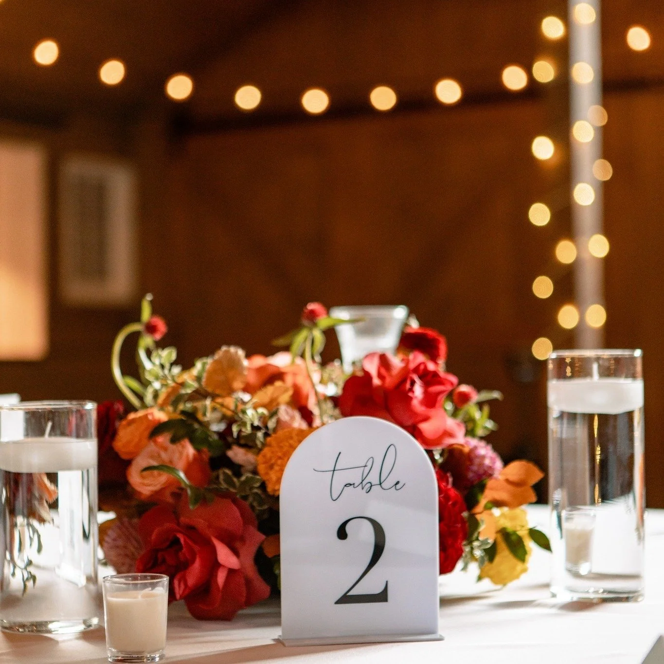 A quiet pause before the party —warm, vibrant florals with those crisp black + white details we can’t get enough of. 
@elevatephotography 
@thebarnatraccooncreek 
@daintydetailscolorado
