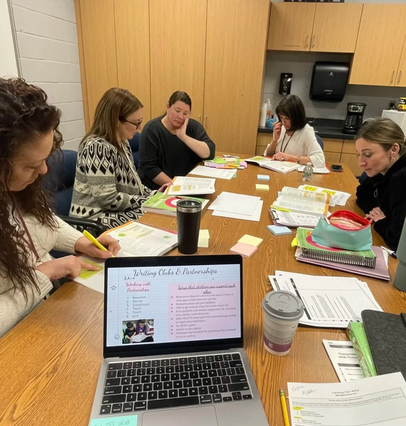 Teachers collaborating to adapt existing curriculum using research-based planning frameworks.