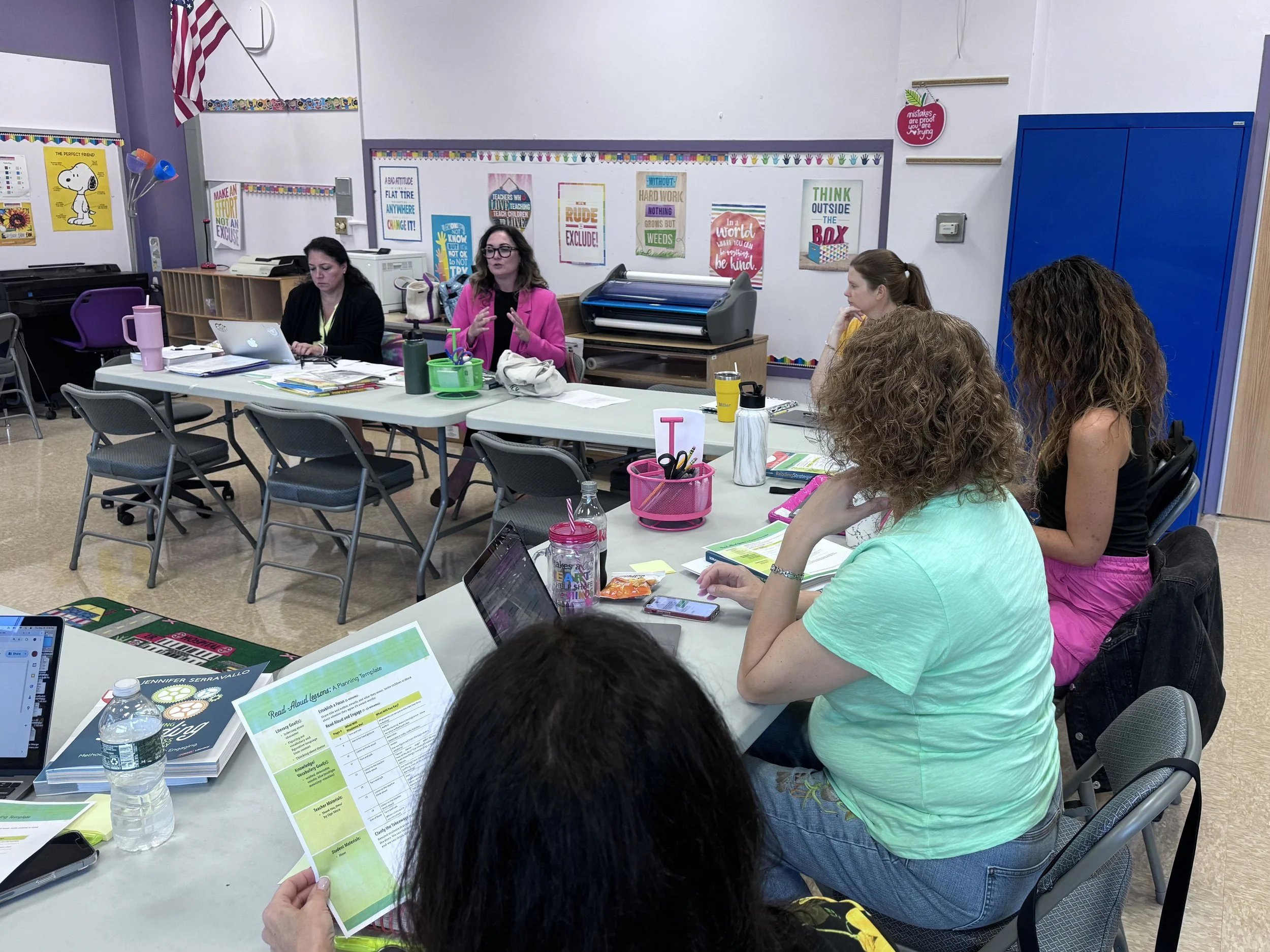 Teachers collaborating on research-aligned lesson planning during curriculum PD session.
