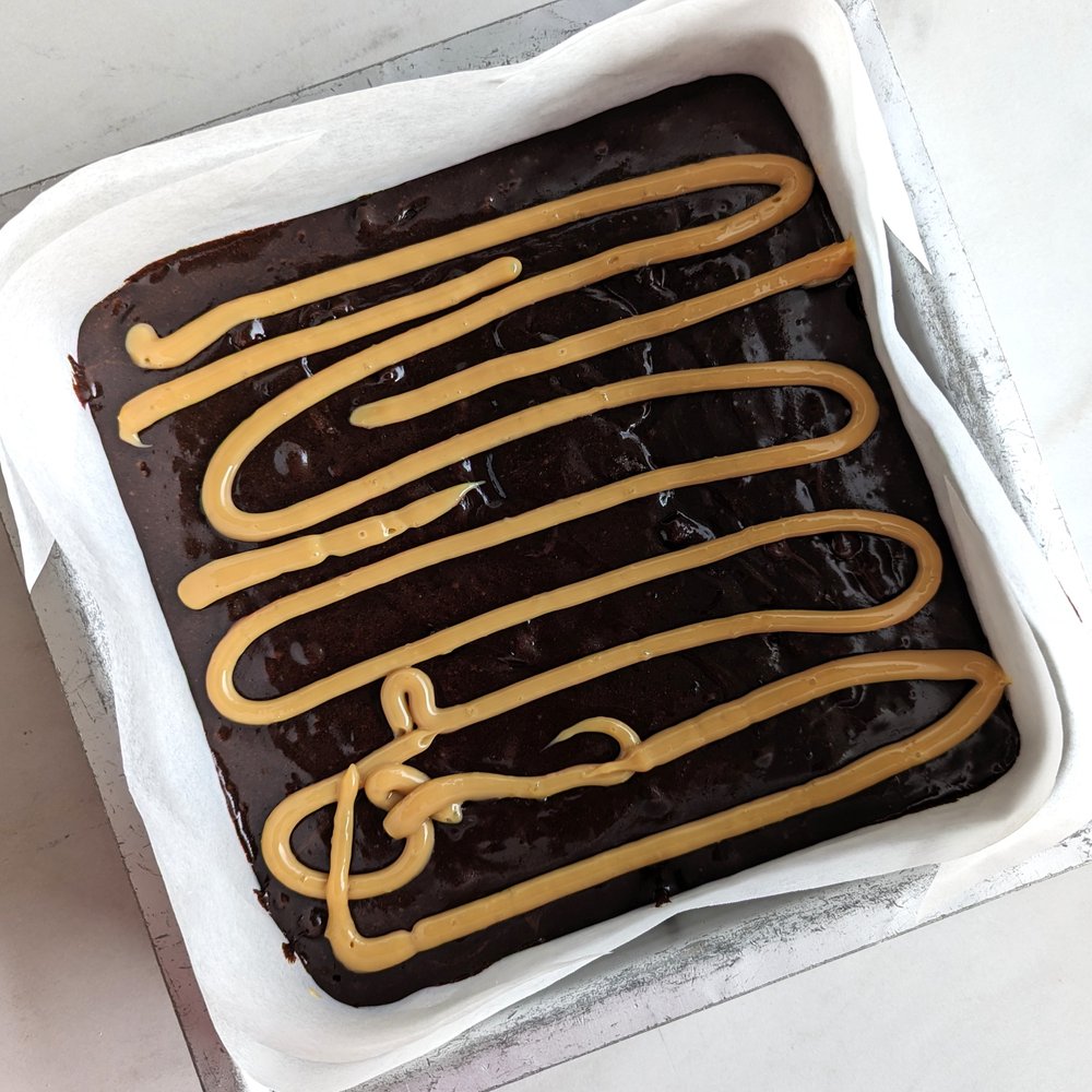 Brownie batter drizzled with dulce de leche.jpg