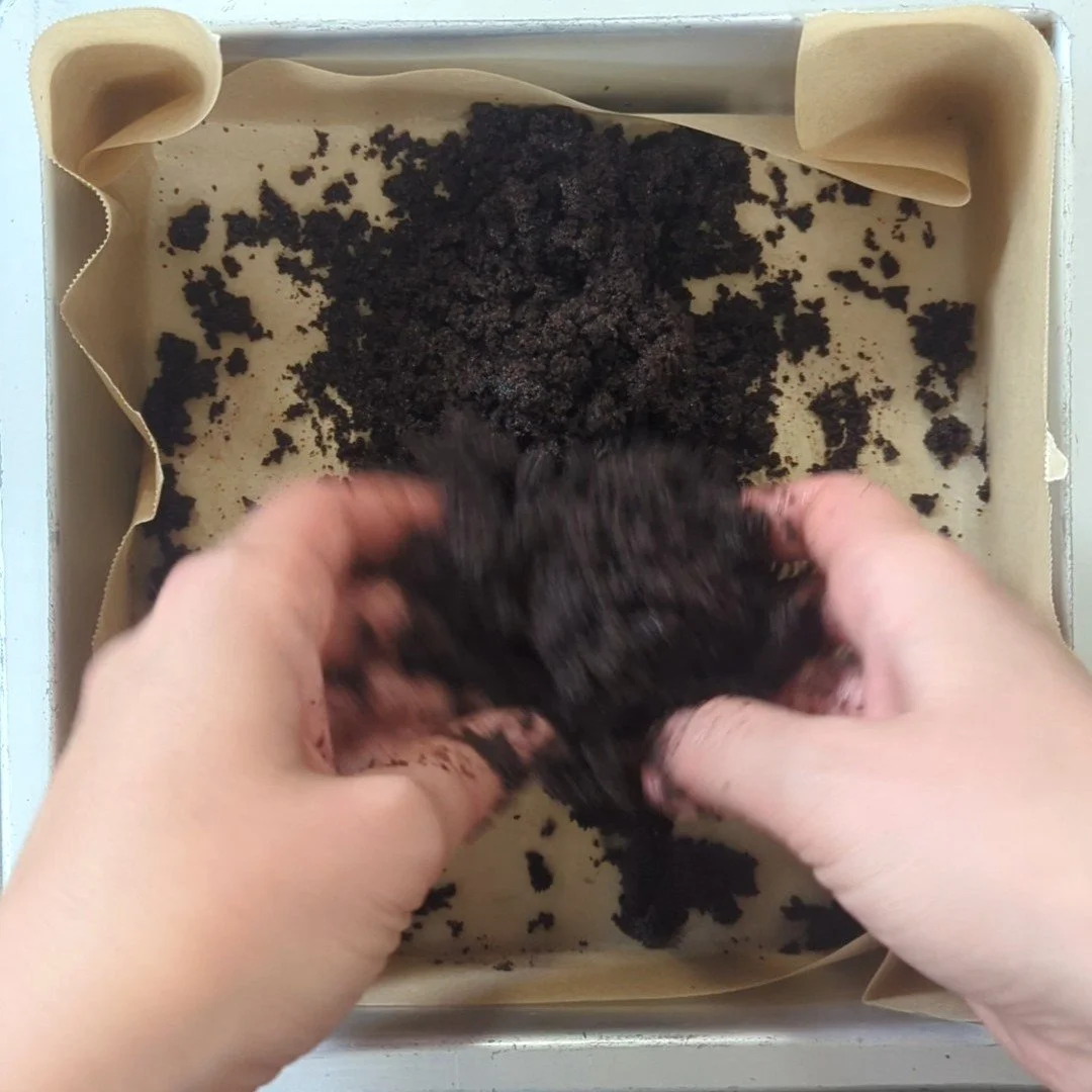 mixing cookie crust with hands.jpg